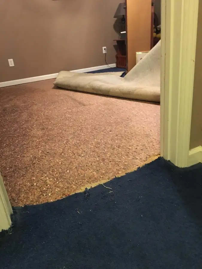 Carpet pad removal revealing water damage during Water Mitigation Services in Suwanee